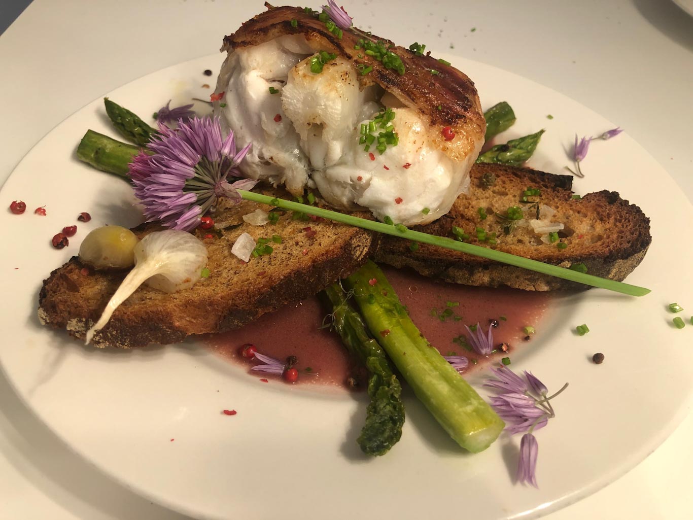 Saltimbocca vom Seeteufel, gebratener grüner Spargel, Sauerteigbrot-Chips und Beurre Rouge